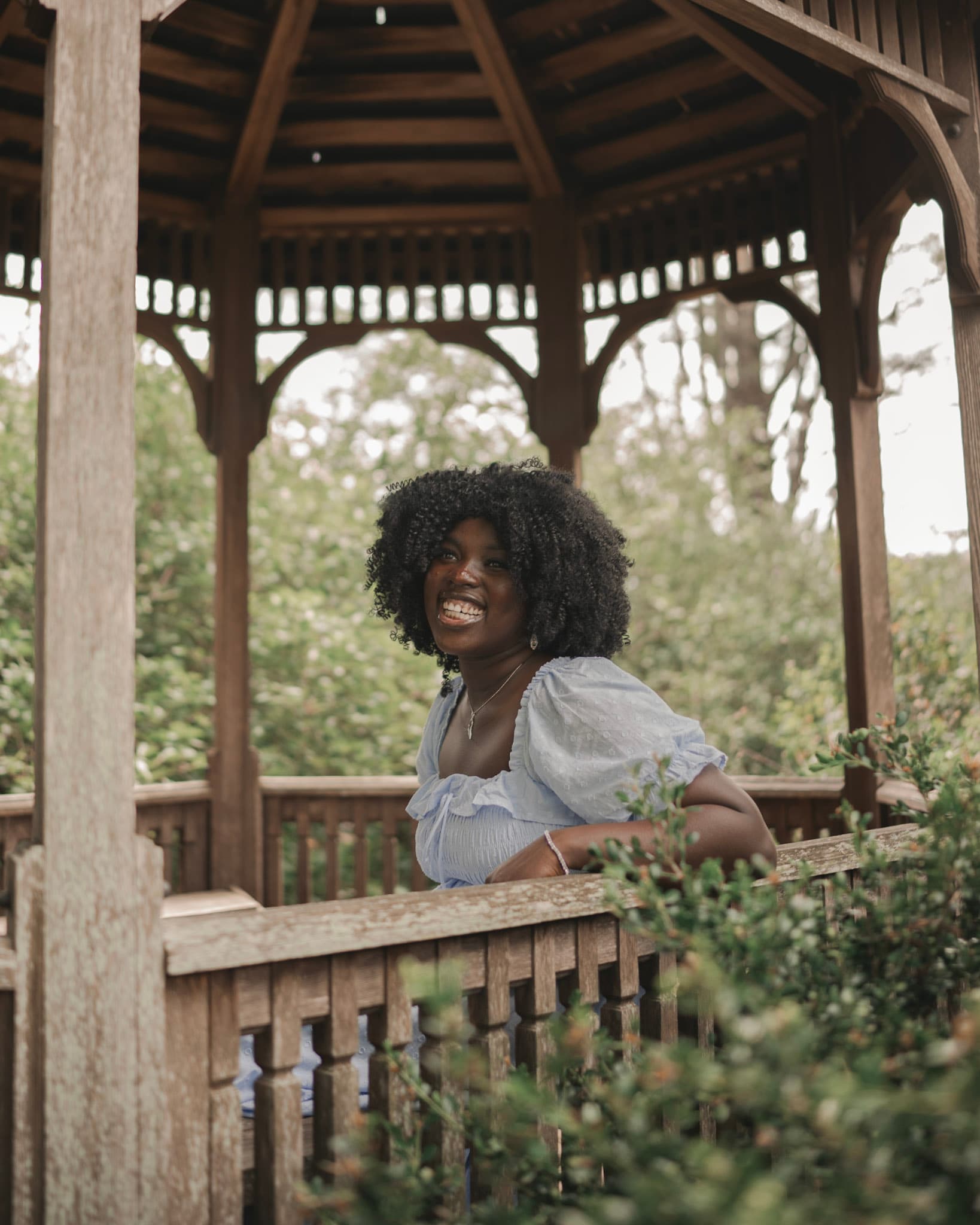 girl in gazebo laughing in the distance
